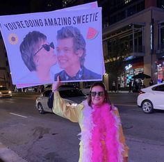 a woman is holding up a sign on the side of the road that says you're doing amazing sweetie