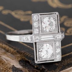 Classic art deco, but with a twist! Two beautiful old European cut diamonds are set in square platinum frames, and surrounded by equally chunky old European cut diamond melee, separated by a dramatically long baguette in the center. Low set on the finger, and simply exquisite! Platinum Size 7.5 & fully resizable Diamonds are estimated to be G/H colors & VVS-SI1 clarities. GIA standards Please see qualitative report for more information. Formal Art Deco Diamond Ring With Baguette Diamonds, Art Deco Jewelry With Rectangular Baguette Diamonds, Art Deco Rectangular Brilliant Cut Diamond Ring, Rectangular Brilliant Cut Diamond Ring In Art Deco Style, Art Deco Platinum Jewelry With Baguette Diamonds, Art Deco Rectangular Baguette Diamond Ring, Art Deco Baguette Diamond Rectangular Ring, Diamond White Rectangular Platinum Diamond Ring, Art Deco Rectangular Diamond Ring For Anniversary