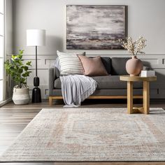 a living room with a couch, coffee table and rug in front of the window