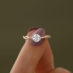 a woman's hand with a diamond ring on her finger and purple nail polish