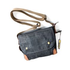 The Men's Canvas Shoulder Bag is a stylish choice for men who are looking for a practical and masculine bag. Made of sturdy canvas with a vintage look, this bag is built to last! A Small Waxed Canvas Crossbody Bag ideal for your travels The men's canvas shoulder bag has a very masculine look with its sleek and stylish design. The flap with snap adds a touch of sophistication to your outfit. The choice of canvas as the material of manufacture adds a vintage touch that will appeal to retro style l Rugged Coated Canvas Bags For Everyday Use, Rugged Everyday Coated Canvas Bags, Travel Coated Canvas Crossbody Bag, Vintage Waxed Canvas Travel Bag, Vintage Canvas Travel Bag With Waxed Finish, Vintage Travel Canvas Bag With Waxed Finish, Rugged Outdoor Shoulder Bag With Adjustable Strap, Outdoor Shoulder Bag In Coated Canvas With Waxed Finish, Classic Outdoor Shoulder Bag With Waxed Finish