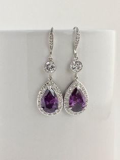 I've created these luxury purple amethyst cubic zirconia bridal tear drop earrings in rhodium plated brass setting. Earrings feature a large teardrop with pear cut purple amethyst cubic zirconia center surrounded by tiny round zirconia crystals. Teardrop dangles from a round cubic zirconia connector and zirconia detailed ear wire. Total length of the earrings is 5 cms. For matching necklace click: https://www.etsy.com/listing/465785454/purple-amethyst-cubic-zirconia-bridal?ref=shop_home_active_2 Purple Crystal Earrings For Wedding, Elegant Lavender Crystal Earrings For Party, Elegant Amethyst Teardrop Dangle Earrings, Purple Bridal Earrings With Matching Set, Elegant Purple Earrings For Pierced Ears, Elegant Lavender Earrings For Party, Elegant Purple Cubic Zirconia Crystal Earrings, Purple Amethyst Jewelry For Pierced Ears, Elegant Purple Drop Crystal Earrings