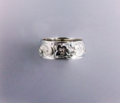 a close up of a ring with flowers on it's side, against a gray background