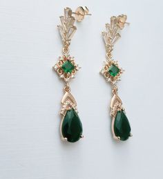 **All orders come with free tracked shipping** High quality champagne gold plated Gatsby style earrings with emerald and clear cubic zirconia stones.  There are 2 jewelry box options: Box A: regular jewelry cardboard box with a textured diamond pattern on the outside (comes in white, black or red) Box B: Velvet earring and necklace box (comes in green, red and grey) You can also add a mini gift bag as show in the pics: comes with green, red or grey satin ribbon and a few sheets of gift tissue pa Art Deco Chandelier Earrings For Formal Occasions, Green Art Deco Drop Earrings, Vintage Gold Earrings For May Birthstone, Elegant Green Crystal Earrings For Pierced Ears, Green Crystal Earrings For Pierced Ears, Art Deco Green Jewelry For Pierced Ears, Elegant Green Crystal Dangle Earrings, Green Teardrop Jewelry For Evening, Vintage Emerald Drop Earrings