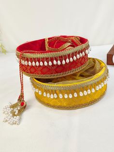 two red and yellow bangles with pearls on them