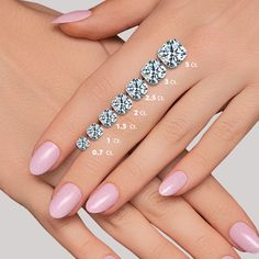 a woman's hand with pink nail polish and diamond ring on it, showing the size