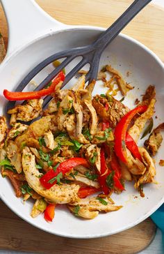 a white bowl filled with chicken and peppers