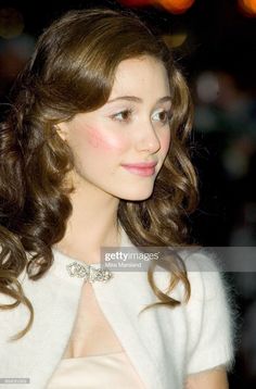 a young woman with long hair wearing a white dress and jacket, looking off to the side