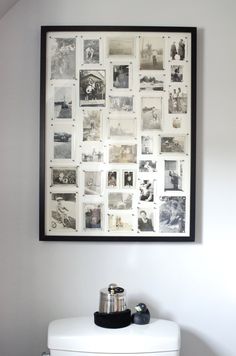 a white toilet sitting next to a wall with pictures on it