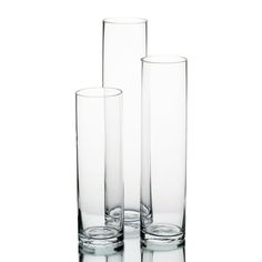 three tall glass vases sitting next to each other