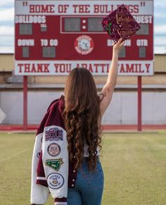 a woman holding up a sign that says home of the bulldogs