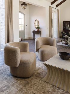 a living room with two chairs and a bowl on the floor