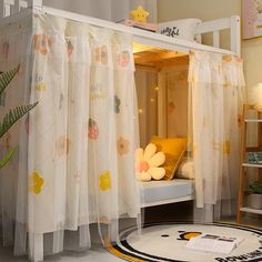 a child's bedroom with a canopy bed and white curtains