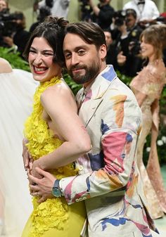 two people standing next to each other in front of photographers and onlookers