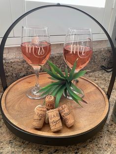 two wine glasses sitting on top of a wooden tray