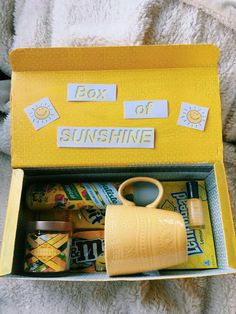 an open yellow box containing various items such as sunflowers, cans and cups