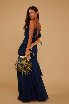 a woman in a blue dress holding a bouquet