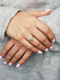 a woman's hand with pink manies and a diamond ring on her finger