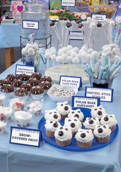 a table topped with lots of cupcakes covered in frosting and toppings