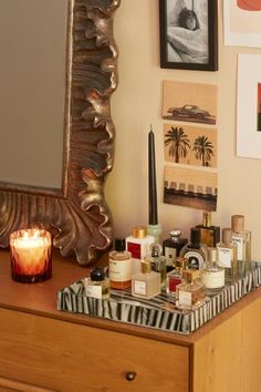 a dresser with candles and pictures on the wall