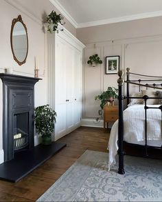 a bed room with a neatly made bed and a fireplace