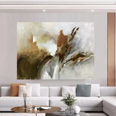 a living room with white couches and a large painting on the wall above it