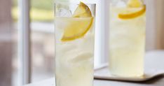 two tall glasses filled with lemonade and ice