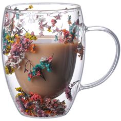 a glass cup filled with liquid and butterflies on the inside is full of colorful flowers