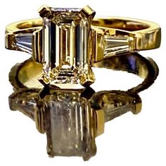 Dekara Design Collection Metal-18K Yellow Gold, 18K White Gold, .750. Stones- Center GIA Certified Emerald Cut Diamond J Color VS1 Clarity 1.62 Carats, Two Sides Baguette Diamonds H-I Color VS1-VS2 Clarity 0.40 Carats. GIA Report # 1353255620 Size- 6 3/4. FREE SIZING!!!! 18K Yellow Gold Emerald Cut Diamond Engagement Ring Handmade By DeKara Designs. Art Deco inspired, Extremely Brilliant, Entirely Handmade, Beautiful Emerald Cut Diamond Engagement Three Stone Ring Made in 18K Yellow Gold. The ce Stone Ring Design, Emerald Cut Diamond Engagement Ring, Emerald Cut Diamond Engagement, Contemporary Engagement Rings, Asscher Cut Diamond, Handmade Engagement Rings, Modern Engagement Rings, Emerald Cut Diamond, Three Stone Engagement