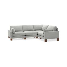 a white sectional couch sitting on top of a wooden table