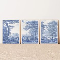 three blue and white wall hangings in front of a beige cloth covered tablecloth