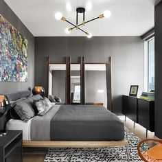 a modern bedroom with grey walls and black furniture