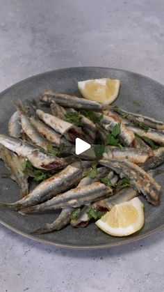 an image of fish on a plate with lemon wedges