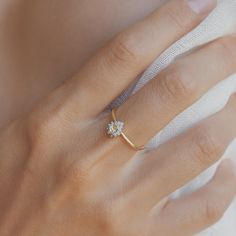 a woman's hand with a diamond ring on it