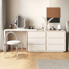 a white dresser sitting next to a mirror on top of a wooden floor in a living room