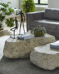 a living room filled with furniture and a statue on top of a stone coffee table