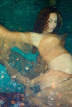 a woman is floating in the water with bubbles