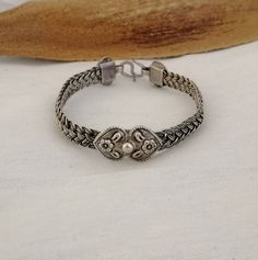 Simultaneously strong and delicate, a band in 4 strands of fine silver woven work encircles the wrist. A beautiful double heart motif carved with flowers sits centrally and is replicated at the closure. Moroccan handmade.  This bracelet is a great addition for everyday wear. Suits larger wrist size.  Weight : 29.5 Silver: stamped 925 Shipping : DHL EXPRESS 🙂 Classic Adjustable Bracelet With Intricate Design, Classic Adjustable Sterling Silver Bracelet With Intricate Design, Classic Silver Adjustable Braided Bracelets, Sterling Silver Bangle With Intricate Design, Handmade Bohemian Bracelets For Anniversary, Handmade Round Sterling Silver Braided Bracelet, Traditional Sterling Silver Adjustable Braided Bracelets, Adjustable Sterling Silver Bracelet With Intricate Design For Anniversary, Traditional Sterling Silver Braided Bracelet, Adjustable