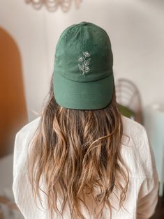 a woman with long hair wearing a green hat