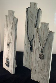 two pieces of wood with necklaces on them