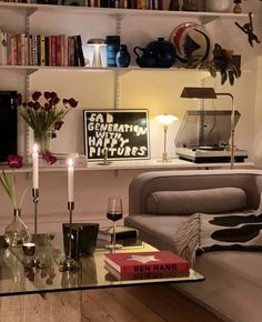 a living room filled with lots of furniture next to a book shelf full of books