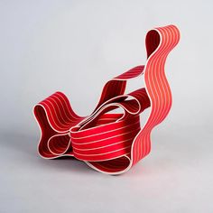 an abstract sculpture made out of strips of red paper