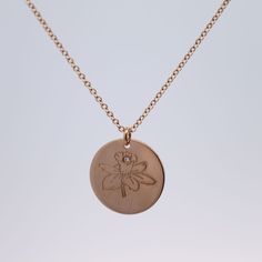 a gold necklace with a flower on it