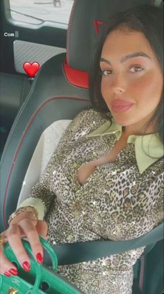 a woman sitting in the back seat of a car with her hand on a purse