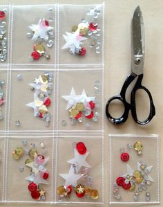 a pair of scissors sitting on top of a table next to christmas decorations and confetti