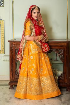 Uppada Silk Wedding sangeet Rajputi poshak in yellow and Red combination with zari work by Saundaryam Fashions Product Details: Boutique design pure Upadda silk poshak with contrast humrahi pure odhna 10 kali  hand work style of antique codding & jari with full kundan Heavy Odhni 4 side work + Jaal desiner work with pallu butta  & gotta kiran turii Kurti with heavy baju & gala work With work magji Color : Same as pr photo ( 5 to 7 % color version may be ) Beautiful crafted Rajputi poshak armlet to increase the beauty of attire and gives stunning traditional look. This products are made from high quality alloy. Traditional Meenakari Anarkali Set In Dola Silk, Dola Silk Anarkali Set With Meenakari For Traditional Ceremonies, Gold Sharara With Dupatta For Traditional Ceremonies, Traditional Gold Sharara With Dori Work, Gold Dola Silk Dupatta For Traditional Ceremonies, Yellow Semi-stitched Sharara For Traditional Ceremonies, Semi-stitched Yellow Sharara For Traditional Ceremonies, Gold Lehenga With Dupatta For Traditional Ceremonies, Traditional Anarkali Set With Gota Work For Puja