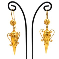 "The Etruscan revival period of the late 1800s was inspired by the findings of archaeological digs in and around Rome. The Etruscans inhabited the area before the Romans did! The ancient jewelry being found was marked by gold granulation, filigree, and classical cultural themes. These Etruscan revival earrings were likely made at the tail of the 19th century and are in the image of ancient amphorae, which were vases used to store and ship goods. The faces of the amphorae are embellished with han Antique Gold Earrings With Historical Design, Antique Drop Earrings With Historical Design, Antique Earrings With Historical Design For Ceremonial Occasions, Ancient Style Yellow Gold Jewelry For Ceremonial Occasions, Ornate Gold Earrings With Historical Design, Traditional Yellow Gold Earrings With Historical Design, Ancient Style Yellow Gold Ceremonial Jewelry, Ancient Yellow Gold Jewelry For Ceremonial Occasions, Victorian Hallmarked Earrings For Ceremonial Occasions