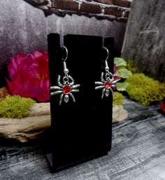 "These earrings features cool tiny spider charms with red rhinestones in them. They are on silver plated ear wires. Small but so cute! Earrings are 1 1/2\" total length and 3/4\" wide *Color may vary slightly due to camera flash or individual computer monitors Store policies: https://www.etsy.com/shop/eternalnightboutique#policies Back to the shop: https://www.etsy.com/shop/eternalnightboutique" Themed Red Earrings, Red Novelty Drop Earrings, Red Novelty Jewelry For Halloween, Halloween Hypoallergenic Metal Jewelry, Halloween Gift Drop Earrings Jewelry, Halloween Gift Drop Earrings, Hypoallergenic Drop Earrings For Halloween, Novelty Hypoallergenic Halloween Jewelry, Silver Themed Earrings For Halloween