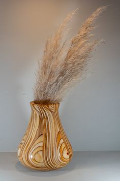 a vase with some grass in it on a table