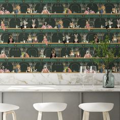 the wallpaper in this kitchen is designed with cats and other animals on shelves, along with white stools